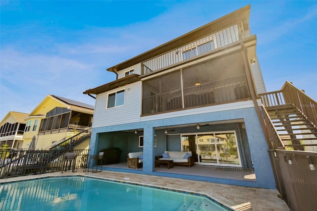 rear view of house with a patio, a balcony, and a fenced in pool