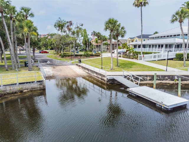 view of dock with a water view and a yard