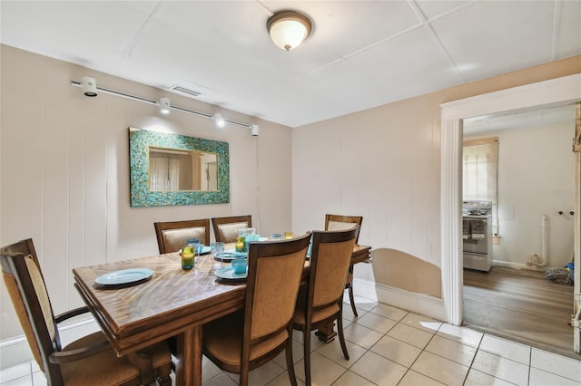 tiled dining area featuring wood walls