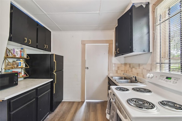 kitchen with black appliances, decorative backsplash, sink, and dark hardwood / wood-style flooring