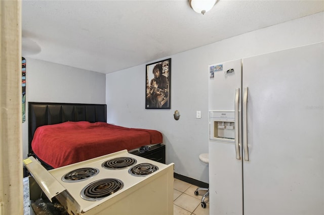 kitchen featuring a textured ceiling, light tile patterned floors, and white appliances