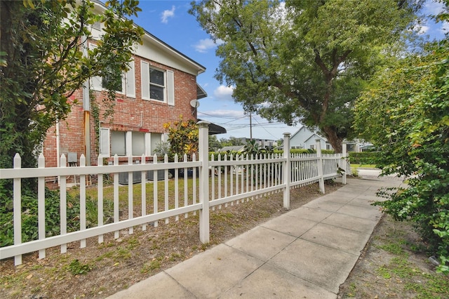 view of side of property featuring brick siding and a fenced front yard