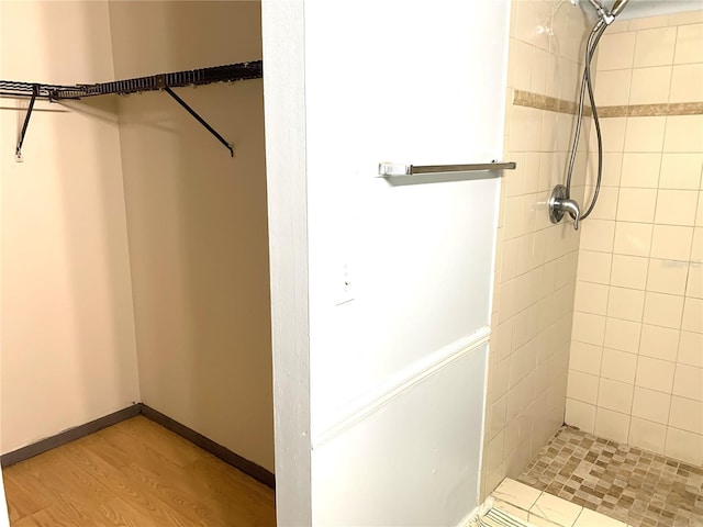 bathroom with hardwood / wood-style flooring and a tile shower