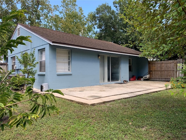 back of house with a lawn and a patio area