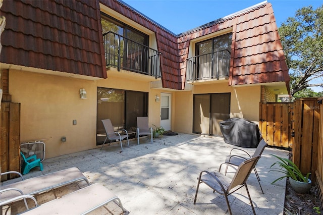 rear view of house featuring a balcony and a patio