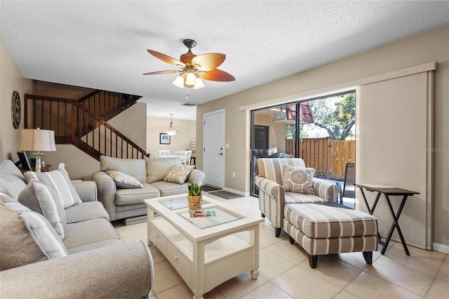 tiled living room with ceiling fan and a textured ceiling