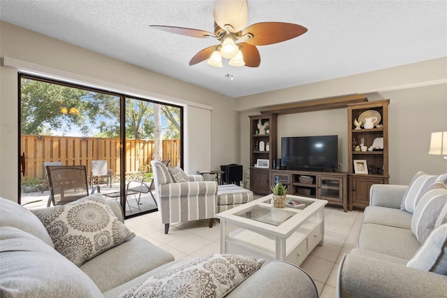 living room featuring a textured ceiling, light tile patterned floors, and ceiling fan