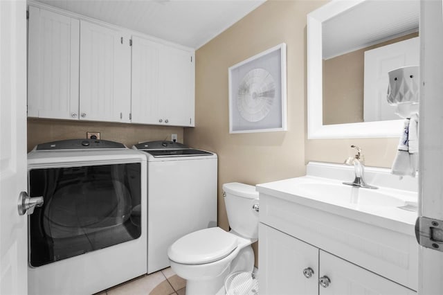 clothes washing area with light tile patterned floors, washer and clothes dryer, and sink