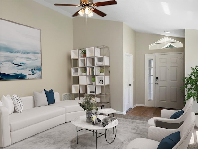 living room featuring ceiling fan, light tile patterned flooring, and lofted ceiling