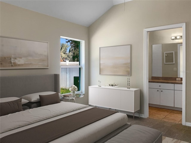 bedroom featuring light colored carpet, lofted ceiling, and ensuite bath