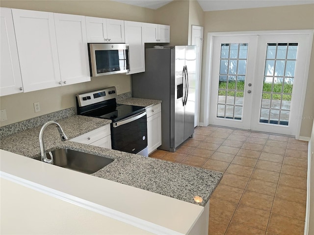 kitchen featuring sink, white cabinets, stainless steel appliances, light stone countertops, and french doors