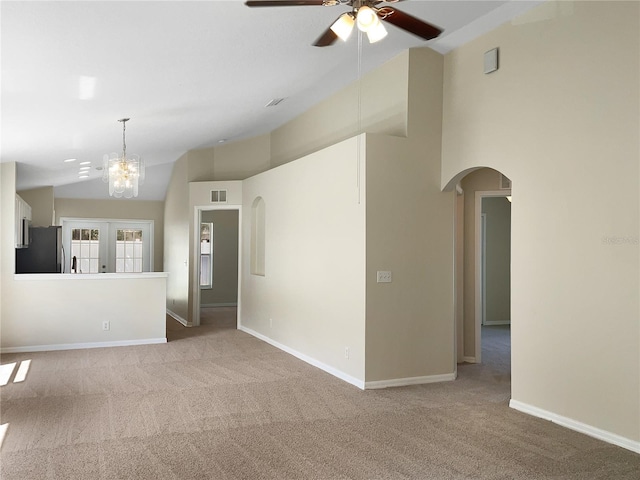 unfurnished room with sink, ceiling fan with notable chandelier, lofted ceiling, light carpet, and french doors