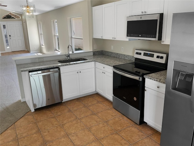 kitchen featuring light tile patterned floors, stainless steel appliances, sink, and white cabinetry