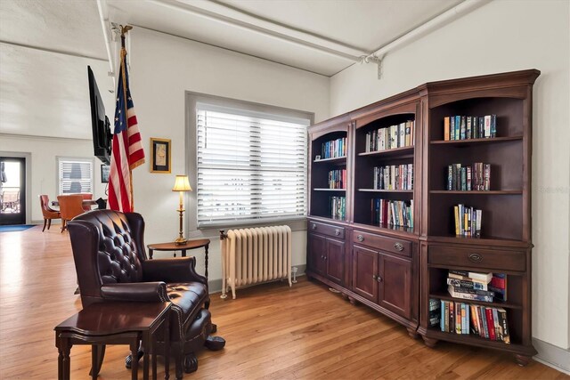 living area featuring radiator and light hardwood / wood-style flooring