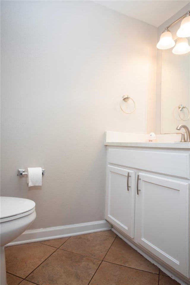 bathroom with tile patterned floors, baseboards, toilet, and vanity