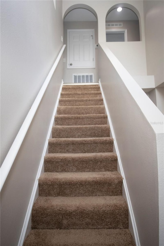 staircase featuring visible vents and baseboards