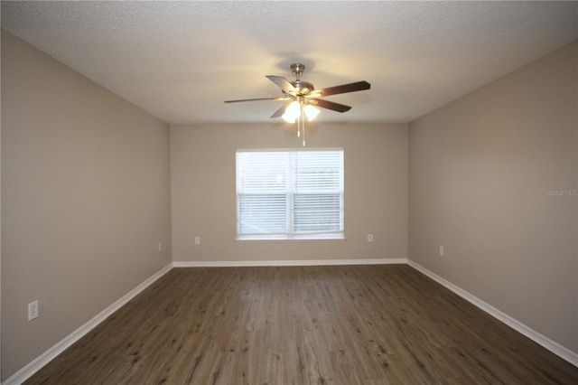 empty room with a textured ceiling, a ceiling fan, dark wood-style flooring, and baseboards