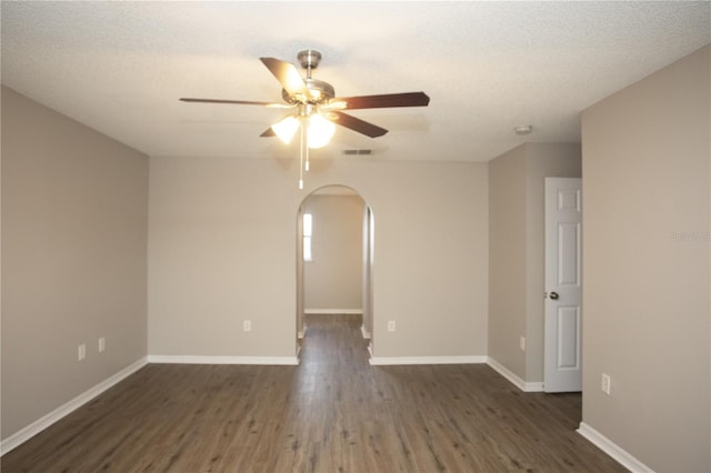 spare room with ceiling fan, dark wood-type flooring, and a textured ceiling