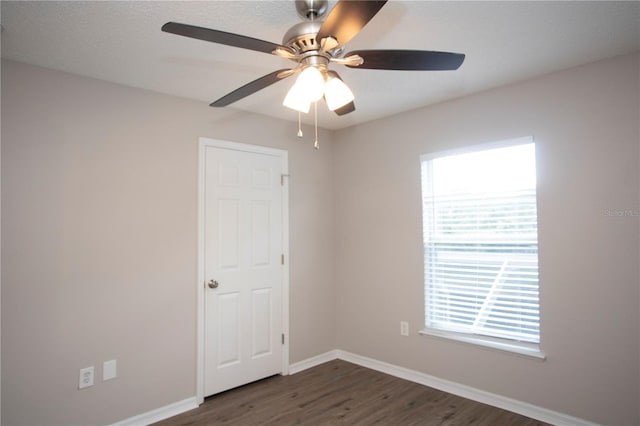 unfurnished room with dark wood-type flooring and ceiling fan