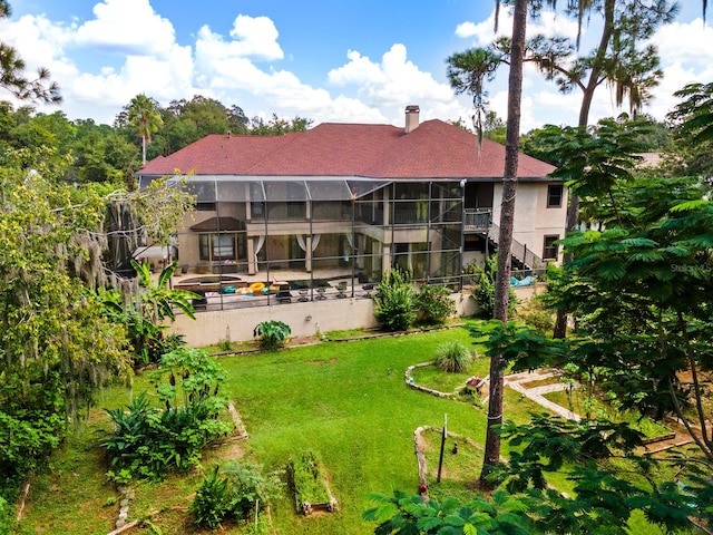 rear view of property with a lawn and a balcony