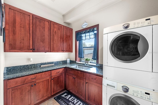 laundry area with cabinets, sink, and stacked washing maching and dryer