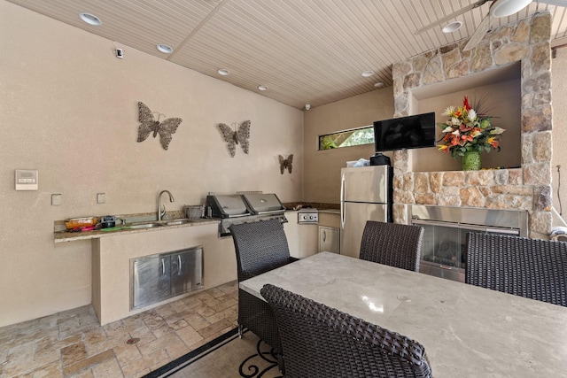 dining area featuring wooden ceiling, a fireplace, and sink