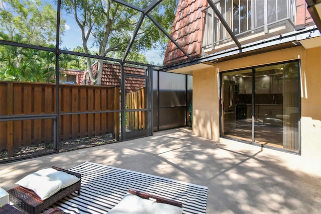 view of patio featuring glass enclosure