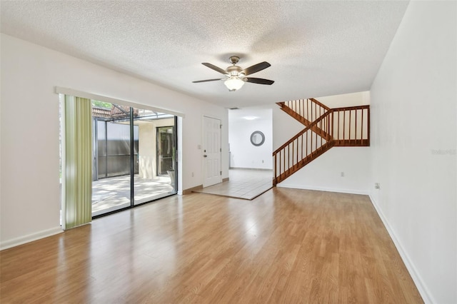 unfurnished living room with light hardwood / wood-style floors, a textured ceiling, and ceiling fan