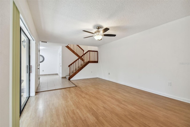 unfurnished room featuring light hardwood / wood-style flooring, a textured ceiling, and ceiling fan