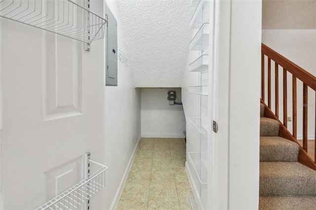 interior space with tile patterned floors, a textured ceiling, and electric panel