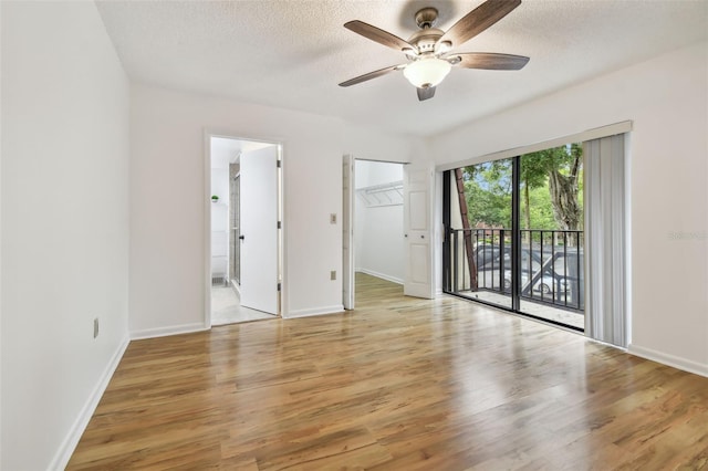 spare room with a textured ceiling, light wood-type flooring, and ceiling fan