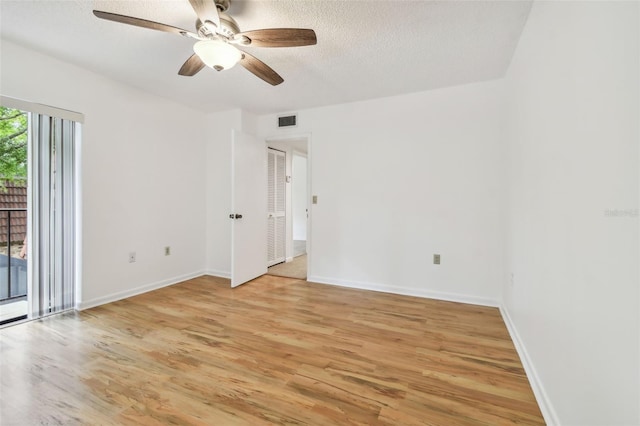 unfurnished room with light hardwood / wood-style flooring, a textured ceiling, and plenty of natural light