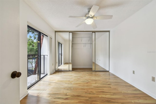 unfurnished bedroom featuring ceiling fan, a textured ceiling, access to exterior, light wood-type flooring, and a closet