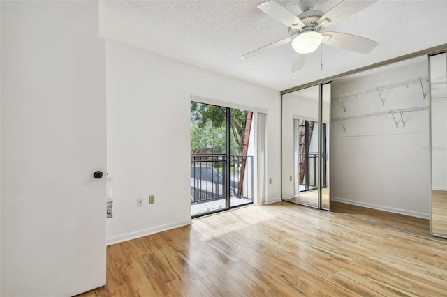 unfurnished bedroom featuring access to exterior, a closet, light hardwood / wood-style flooring, a textured ceiling, and ceiling fan