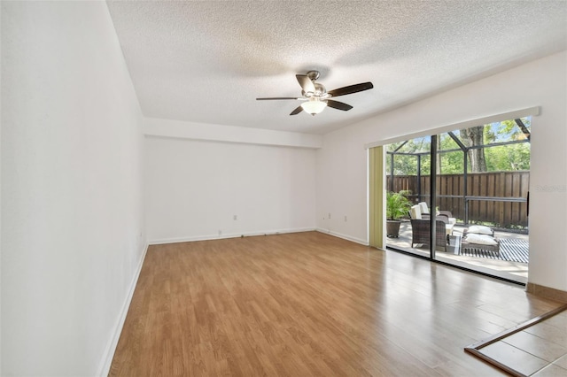 unfurnished room with ceiling fan, wood-type flooring, and a textured ceiling