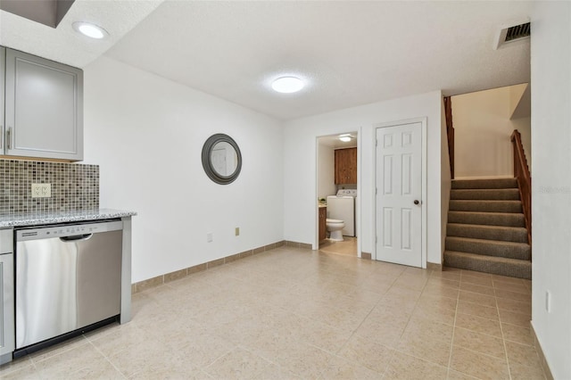 interior space featuring washer / dryer, light tile patterned flooring, and a textured ceiling