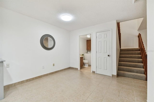 spare room with washer / dryer and a textured ceiling