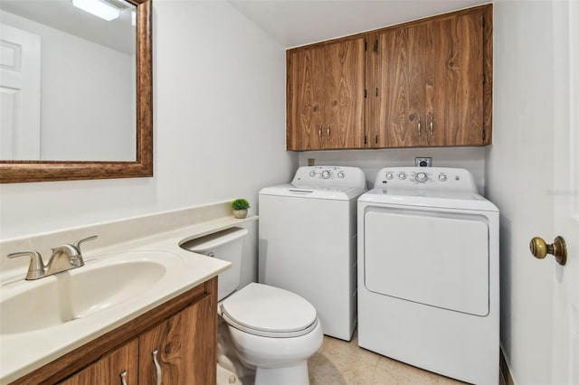 bathroom with vanity, washing machine and dryer, and toilet