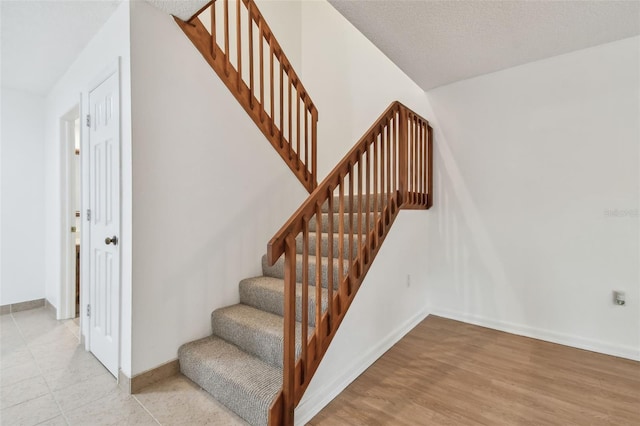 stairs featuring hardwood / wood-style floors and a textured ceiling