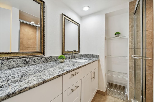 bathroom featuring vanity, tile patterned floors, and walk in shower