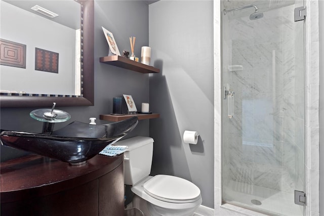 bathroom featuring vanity, toilet, and a shower with door