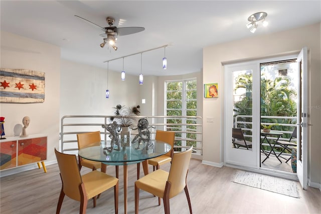 dining space featuring light wood-type flooring, rail lighting, and ceiling fan