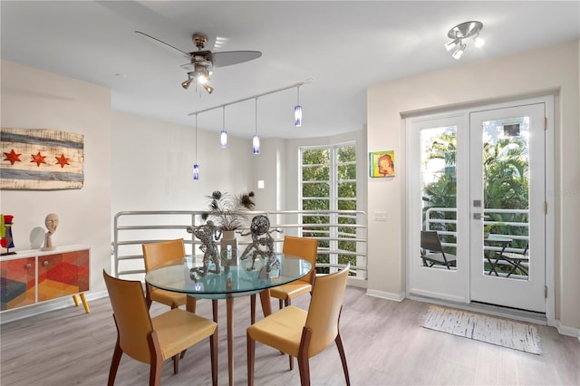 dining room with ceiling fan, rail lighting, and light wood-type flooring