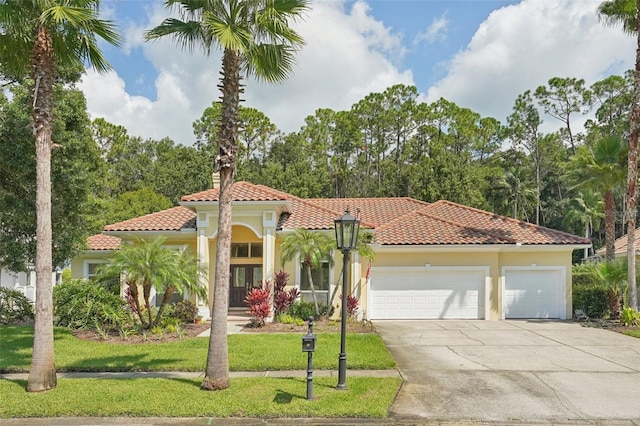 mediterranean / spanish-style house featuring a front yard and a garage