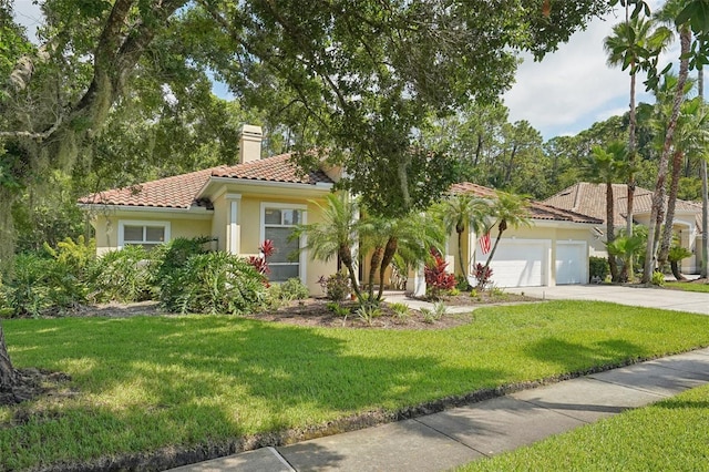 mediterranean / spanish-style house featuring a front yard and a garage