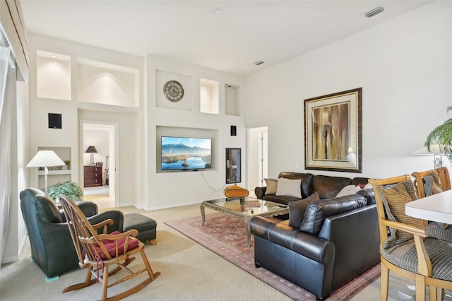 carpeted living room featuring a high ceiling