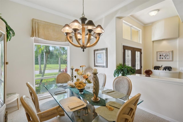 dining space with an inviting chandelier, crown molding, carpet floors, and french doors