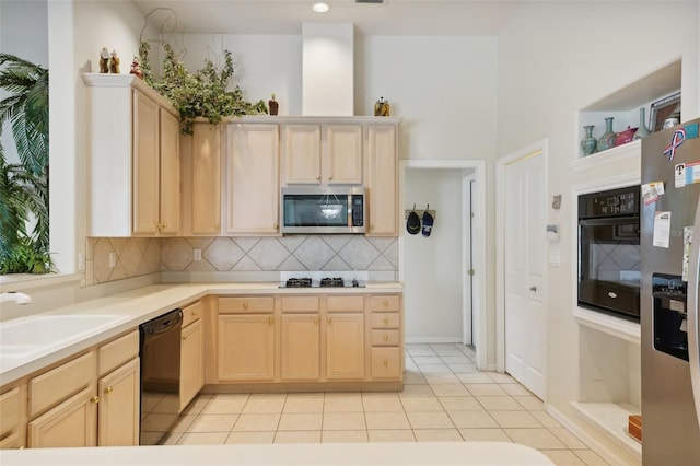 kitchen featuring light brown cabinets, backsplash, light tile patterned flooring, black appliances, and sink