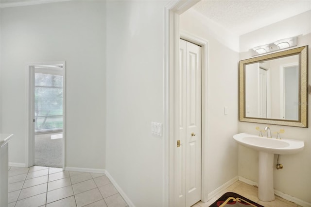 bathroom with a textured ceiling and tile patterned flooring