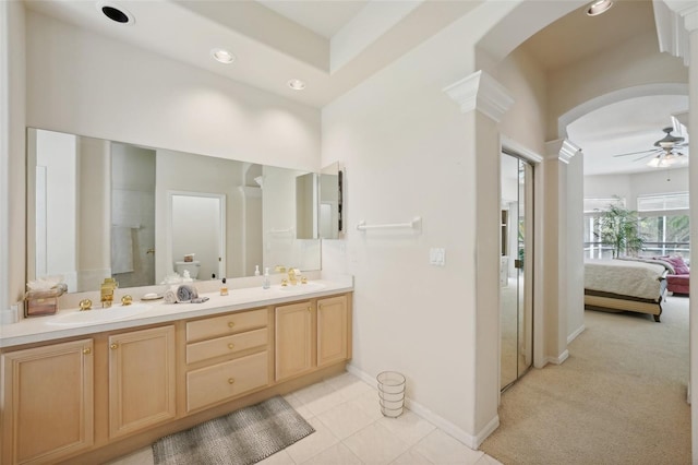 bathroom with a shower with shower door, ornate columns, ceiling fan, tile patterned floors, and vanity